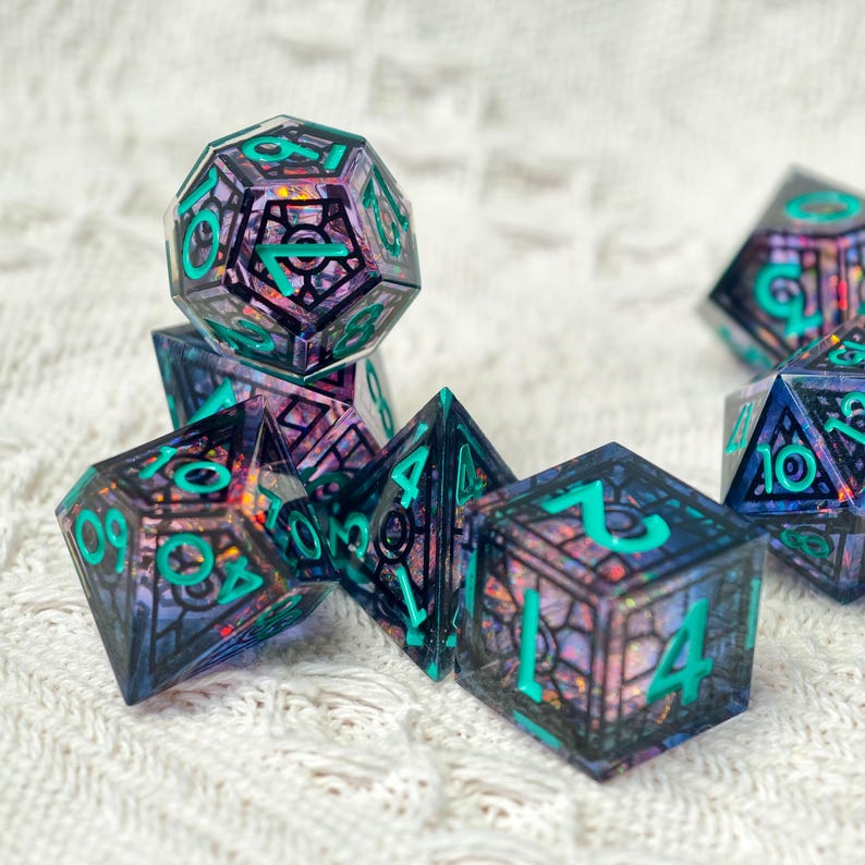 May include: A set of polyhedral dice featuring a dark, translucent purple resin base with embedded iridescent flakes and a black geometric cage overlay. The numbers are engraved in a bright teal color, providing high contrast against the dark dice.