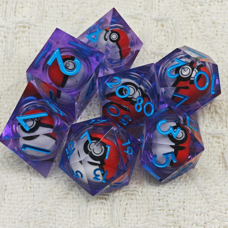 May include: Set of six purple and blue translucent dice with a white and red Pokeball design inside. The dice are numbered 1 through 6.