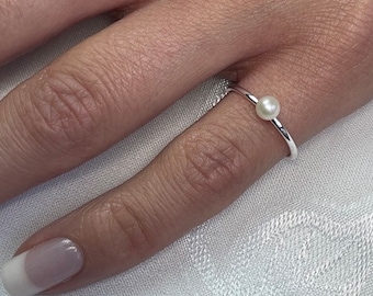 May include: A simple silver ring with a single white pearl.