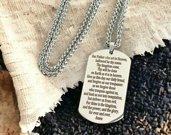 May include: A silver chain necklace with a silver dog tag pendant. The dog tag has the Lord's Prayer engraved on it.