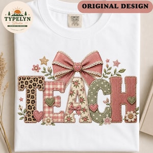 Pode incluir: Uma t-shirt branca com a palavra TEACH em letras grandes e estampadas. O T tem estampa de leopardo, o E é xadrez rosa, o A tem um padrão floral, o C é verde com bolinhas brancas e o H é rosa sólido. Um grande laço rosa está acima.
