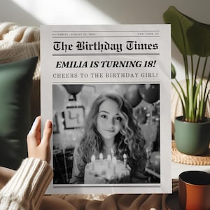 May include: A black and white newspaper-style print titled "The Birthday Times." The headline reads "EMILIA IS TURNING 18!" with a photo of a young woman holding a cake. The date is Saturday, August 20, 2024.