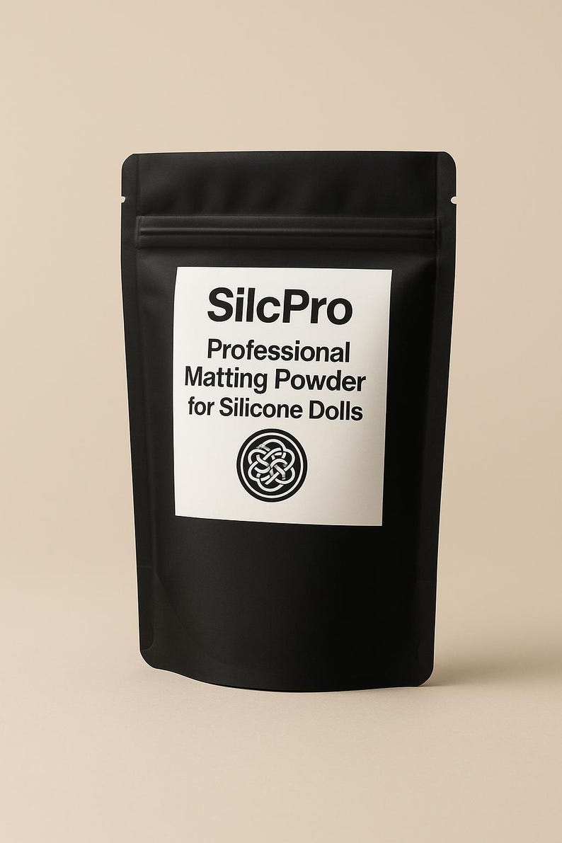 Puede incluir: Bolsa negra de SilcPro Professional Matting Powder para mu&ntilde;ecas de silicona. El nombre del producto y la descripci&oacute;n est&aacute;n impresos en blanco sobre una etiqueta blanca. Un dise&ntilde;o circular est&aacute; debajo del texto.