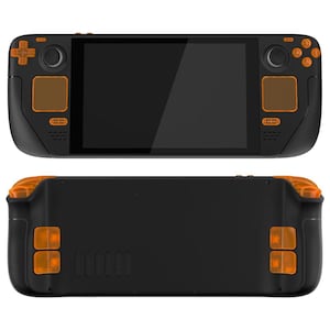 Peut inclure: Une console de jeu portable noire avec des boutons orange et un écran tactile. La console a un dos noir texturé avec une grille de haut-parleur et des boutons orange supplémentaires.