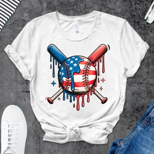 K&ouml;nnte beinhalten: Wei&szlig;es T-Shirt mit einem Baseball-Design in Rot, Wei&szlig; und Blau. Der Baseball hat ein Sternen- und Streifenmuster mit tropfendem Farbeffekt. Zwei gekreuzte Baseballschl&auml;ger, einer blau und einer rot, befinden sich dahinter.