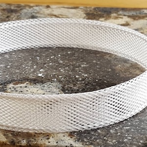 May include: White mesh headband with a diamond pattern. The headband is made of a soft, flexible material and is perfect for adding a touch of style to any outfit.