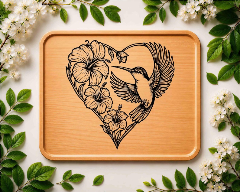 K&ouml;nnte beinhalten: Ein rechteckiges Tablett aus hellem Holz mit einer schwarzen Strichzeichnung in der Mitte. Das Motiv zeigt einen fliegenden Kolibri neben drei Hibiskusbl&uuml;ten, die zusammen eine herzf&ouml;rmige Kontur bilden.
