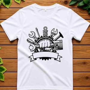 Pode incluir: Uma t-shirt branca de manga curta com uma impress&atilde;o gr&aacute;fica preta de um punho cerrado segurando uma chave inglesa, rodeado por ferramentas mec&acirc;nicas, incluindo uma engrenagem, um pist&atilde;o, uma chave de fendas e uma chave, com uma faixa vazia na parte inferior.