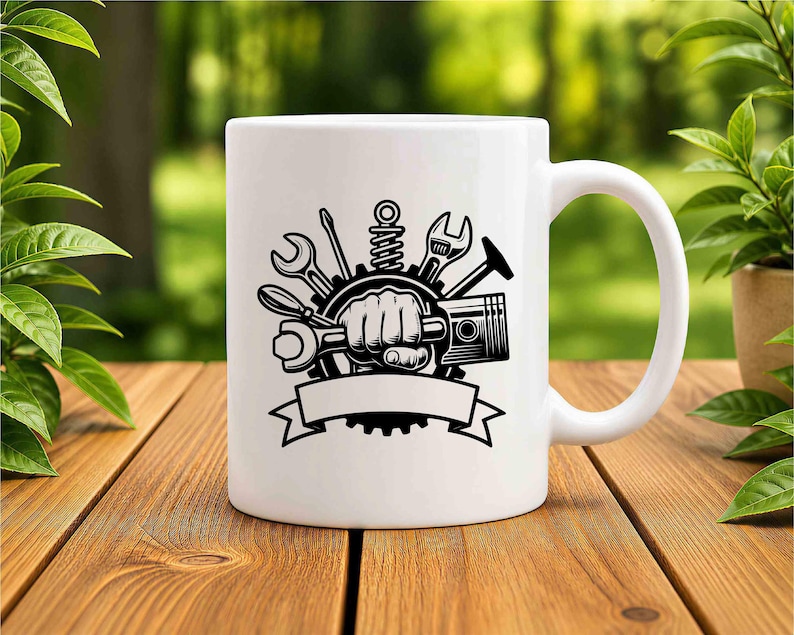 Pode incluir: Uma caneca de cer&acirc;mica branca com uma estampa gr&aacute;fica preta de um punho cerrado segurando uma chave inglesa, rodeado por v&aacute;rias ferramentas mec&acirc;nicas, incluindo uma chave de fenda, uma mola e uma engrenagem, com uma faixa vazia na base.