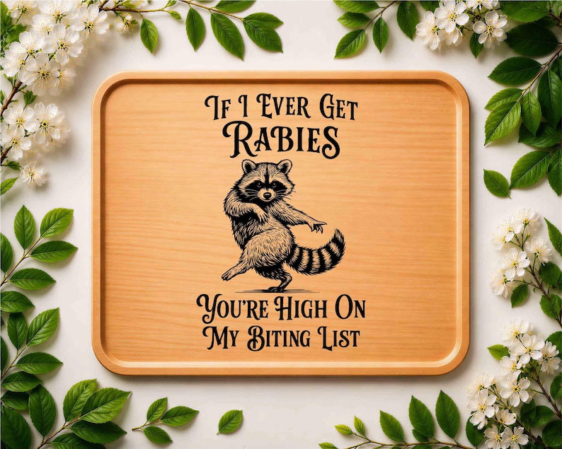 May include: A rectangular light brown wooden serving tray featuring a black graphic illustration of a dancing raccoon in the center. The text reads: If I Ever Get RABIES YOU'RE HIGH ON MY BITING LIST. The tray has rounded corners and raised edges.