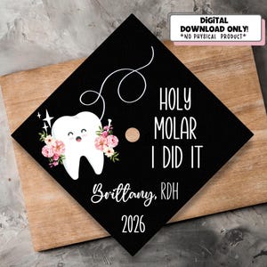 以下が含まれることがあります： 「HOLY MOLAR I DID IT」の文字と「Brittany, RDH 2026」の名前が入った黒い卒業キャップ。キャップには、花のアクセントが付いた笑顔の歯のグラフィックと「DIGITAL DOWNLOAD ONLY! *NO PHYSICAL PRODUCT*」の文字が描かれています。
