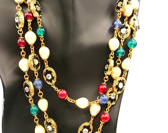 May include: A multi-strand gold-tone chain necklace featuring an assortment of white faux pearls, translucent blue, green, and red beads, and circular black enamel links with central clear rhinestones set in ornate gold-tone metal frames.