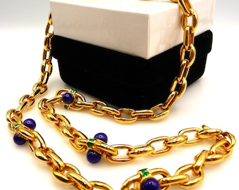 May include: A gold-tone chain necklace featuring large oval links. The necklace is accented with round, deep blue beads and small, rectangular green enamel inserts placed at intervals along the length of the metallic chain.