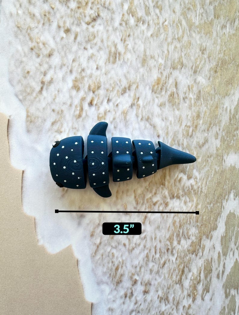 May include: A blue and white whale shark toy with white polka dots. The toy is 3.5 inches long.