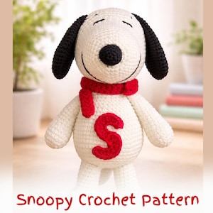 May include: A crocheted Snoopy doll with black ears, a black nose, and a red scarf. The white body features a large red letter "S". The text "Snoopy Crochet Pattern" is displayed at the bottom of the image.