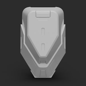 Op de afbeelding: Een grijs, geometrisch gevormd, 3D-geprint model van een futuristische helm. De helm heeft een glad, afgerond oppervlak met een reeks verhoogde lijnen en richels.