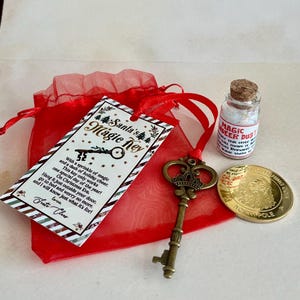 May include: A Christmas-themed set including a decorative key, a small bottle of "Magic Deer Dust", a gold coin, and a red organza bag with a tag that reads "Santa's Magic Key".