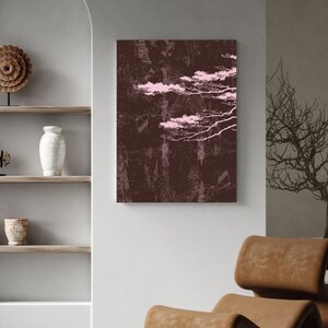 Peut inclure: Impression d'art abstrait avec un fond marron foncé, des formes roses en forme de nuages et des accents linéaires blancs. L'œuvre est accrochée à un mur blanc, complétée par une chaise en cuir marron. Thème : décoration intérieure moderne.