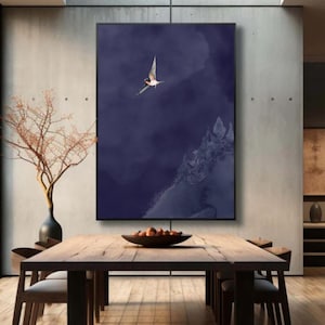 Peut inclure: Une impression d'art encadrée représentant un oiseau en vol sur un fond bleu foncé abstrait. L'œuvre est exposée au-dessus d'une table à manger en bois avec des chaises. Un vase avec des branches et un bol de fruits sont également visibles.