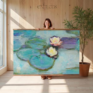 May include: A framed canvas print featuring a water lily pond scene with white and yellow flowers, green lily pads, and a light blue water background. The artwork is held by a person. The word "ENDLESS" is printed at the top.