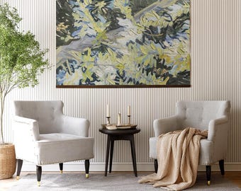 May include: A rectangular wall art piece featuring an abstract painting with thick, textured brushstrokes in shades of olive green, navy blue, and cream, framed in dark wood, displayed above two light gray upholstered armchairs and a side table.