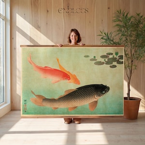 May include: A framed art print featuring a traditional Japanese painting of koi fish. The artwork depicts three koi in shades of red, orange, and black, swimming in a pond with lily pads. The print has a wooden frame and is displayed indoors.