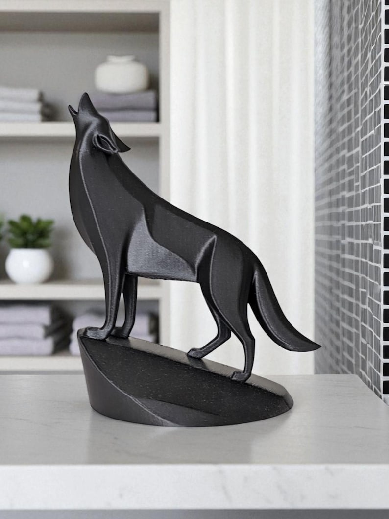 May include: A black wolf sculpture in a howling pose, mounted on a small, angled base. The figurine is set against a neutral background, showcasing the detailed form of the animal. The sculpture is likely made of a solid material.