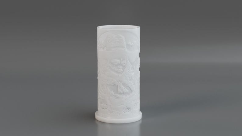 May include: A white cylindrical vase with a detailed relief pattern. The vase has a wide base and a smooth, rounded top. The relief design appears to depict a natural scene with various elements. The vase is made of a solid, opaque material.
