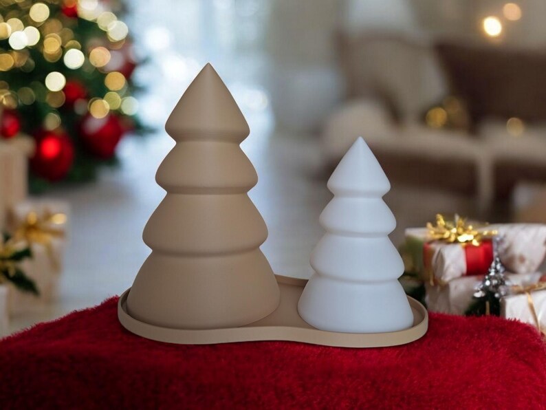 May include: Two ceramic Christmas tree decorations, one brown and one white, on a red surface. The trees are stylized and have a rounded, three-dimensional shape.