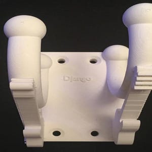 May include: White 3D-printed wall mount with two curved arms and a central mounting plate. The word "Django" is printed on the plate. The mount has a series of holes for screws.