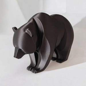 May include: A dark brown bear figurine with a geometric design. The bear is standing on all fours, with its head slightly lowered. The figurine has a smooth, matte finish and is a decorative item.