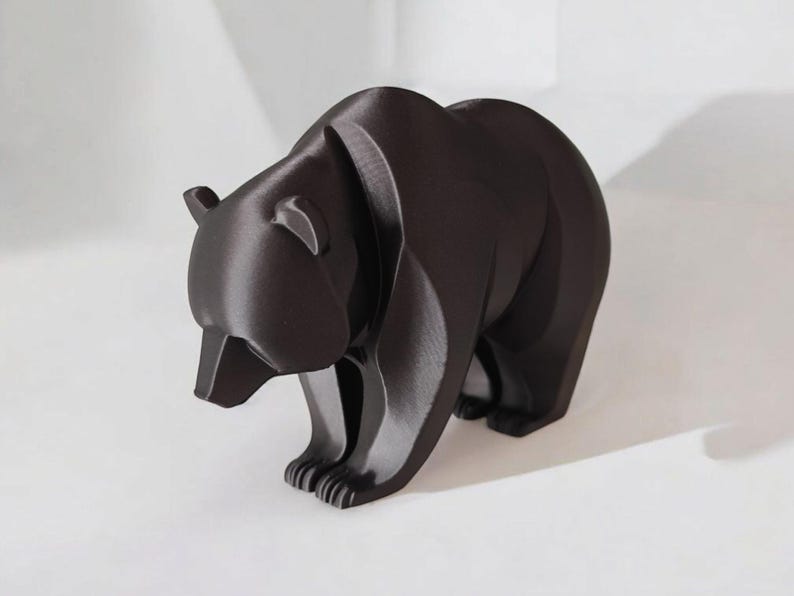 May include: A dark brown bear figurine with a geometric design. The bear is standing on all fours, with its head slightly lowered. The figurine has a smooth, matte finish and is a decorative item.