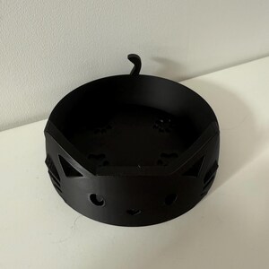Puede incluir: Un cuenco negro de metal con forma de gato. El cuenco tiene cortes para los ojos y la nariz, con una peque&ntilde;a cola que se extiende desde la parte superior. El cuenco es redondo con una base plana y est&aacute; dise&ntilde;ado para guardar objetos peque&ntilde;os.