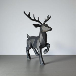 May include: A geometric, black deer sculpture with a modern design. The deer is depicted in a running pose, with its antlers prominently displayed. The sculpture is made of a matte material and sits on a gray surface.