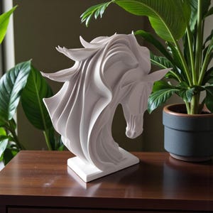 May include: A white, abstract horse head sculpture with flowing mane and a square base. The sculpture is displayed on a dark brown wooden surface, with green plants in the background. The horse sculpture is a decorative home accent.