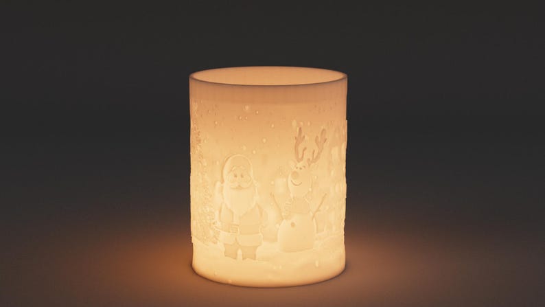 May include: A cylindrical, off-white ceramic candle holder with a Christmas theme. The design features embossed images of Santa Claus, a snowman, and reindeer. The candle holder is illuminated from within, creating a warm, inviting glow.
