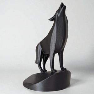 May include: A black sculpture of a howling wolf, standing on a small, rounded base. The wolf is depicted with its head raised and mouth open, in a stylized, modern design. The sculpture is made of a solid, matte black material.