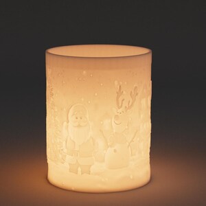 May include: A cylindrical, off-white Christmas candle holder with embossed holiday figures. Santa Claus, a snowman, and a reindeer are depicted on the sides. The candle holder is illuminated from within, creating a warm, inviting glow.