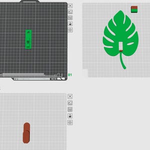 以下が含まれることがあります： 葉っぱに似た3Dプリントされた緑色のオブジェクトと、緑色の長方形のオブジェクト。葉には茎と真ん中に穴があります。長方形のオブジェクトには、真ん中に長方形の穴があります。オブジェクトは灰色の表面にあります。