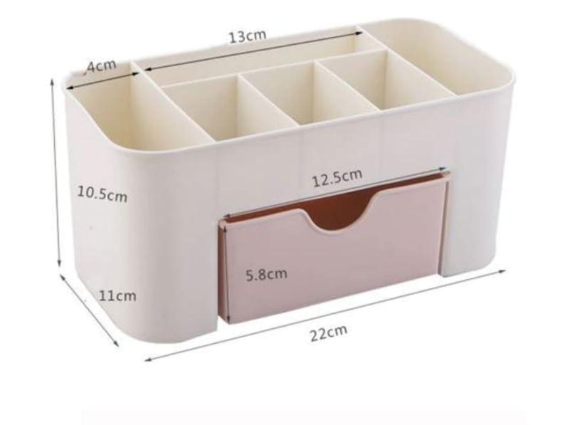 May include: A white and pink organizer with multiple compartments and a drawer. The organizer is 22 cm long, 11 cm wide, and 10.5 cm tall. The drawer is 12.5 cm wide and 5.8 cm tall. The compartments are 13 cm wide and 4 cm deep.
