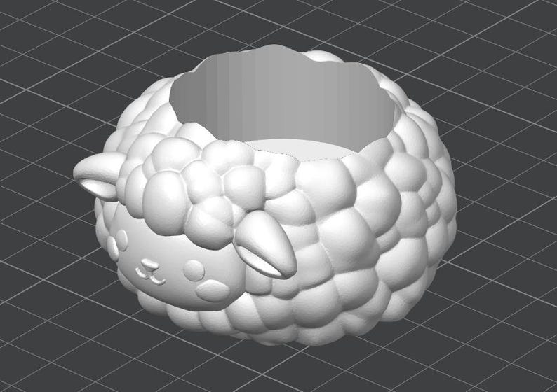 May include: A white, 3D-printed sheep-shaped planter. The planter has a round body with a textured, bubbly surface, and a sheep face with small ears. The interior is hollow, creating a space for plants or other items.