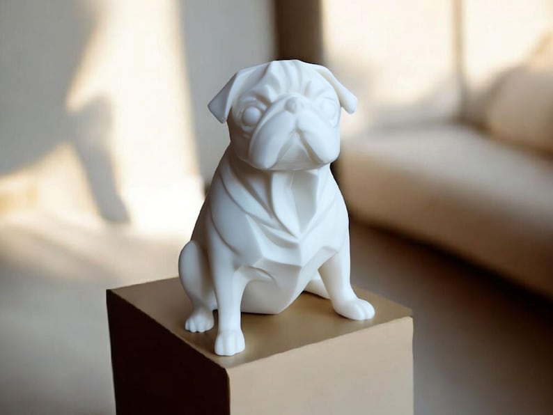 K&ouml;nnte beinhalten: Eine wei&szlig;e Keramik-Mops-Figur mit geometrischem Design. Der Mops sitzt auf einer quadratischen, hellbraunen Box. Die Figur hat detaillierte Gesichtsz&uuml;ge und ist ein dekorativer Gegenstand.