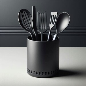 May include: A black kitchen utensil set includes a whisk, spatula, slotted turner, slotted spoon, and solid spoon. The utensils are in a black cylindrical holder with a row of small holes near the base. The set is on a white surface against a dark gray background.