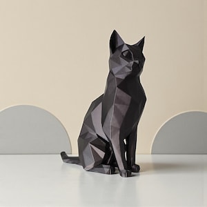 May include: A black geometric cat sculpture. The cat is in a seated position with its tail curled to the side. The sculpture is made of multiple triangular shapes, giving it a modern, angular appearance. The cat is on a white surface.