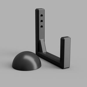 May include: A black, L-shaped bracket with three holes and a rounded base. The bracket is made of a solid material and is designed to hold an object. The base is a half-sphere shape.