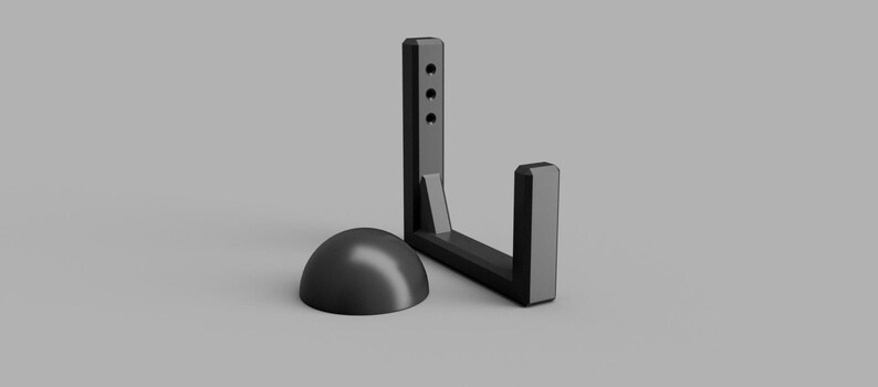 May include: A black, L-shaped bracket with three holes and a rounded base. The bracket is made of a solid material and is designed to hold an object. The base is a half-sphere shape.