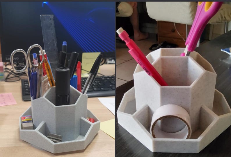 May include: A light gray desk organizer with multiple compartments for pens, pencils, and other office supplies. The organizer has a hexagonal shape with several angled storage areas. A roll of tape and various writing utensils are visible.