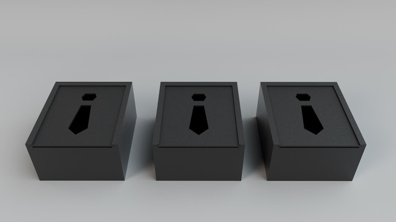 May include: Three black boxes with a tie-shaped cutout on the front. The boxes are angled and have a simple, modern design. The tie cutout is a solid black shape. The boxes are likely for storing small items.