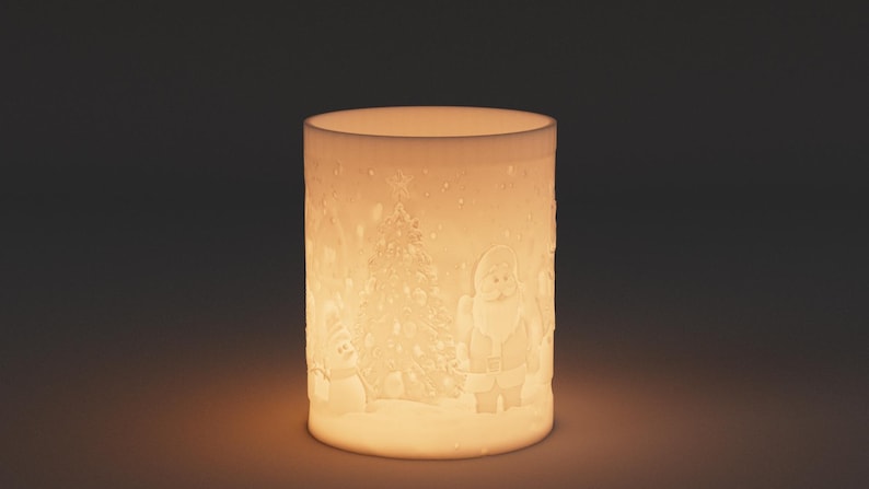 May include: A cylindrical, off-white Christmas candle holder with a festive design. The design includes a Christmas tree, Santa Claus, and a snowman, all set against a snowy landscape. The candle holder is illuminated from within, creating a warm glow.