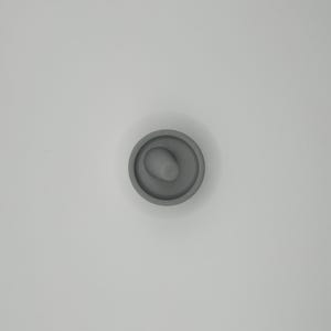 Pode incluir: Uma rolha cinzenta com um design circular e uma pega cil&iacute;ndrica saliente. A rolha &eacute; feita de um material s&oacute;lido e foi concebida para se encaixar na abertura de uma garrafa. O design &eacute; simples e funcional.